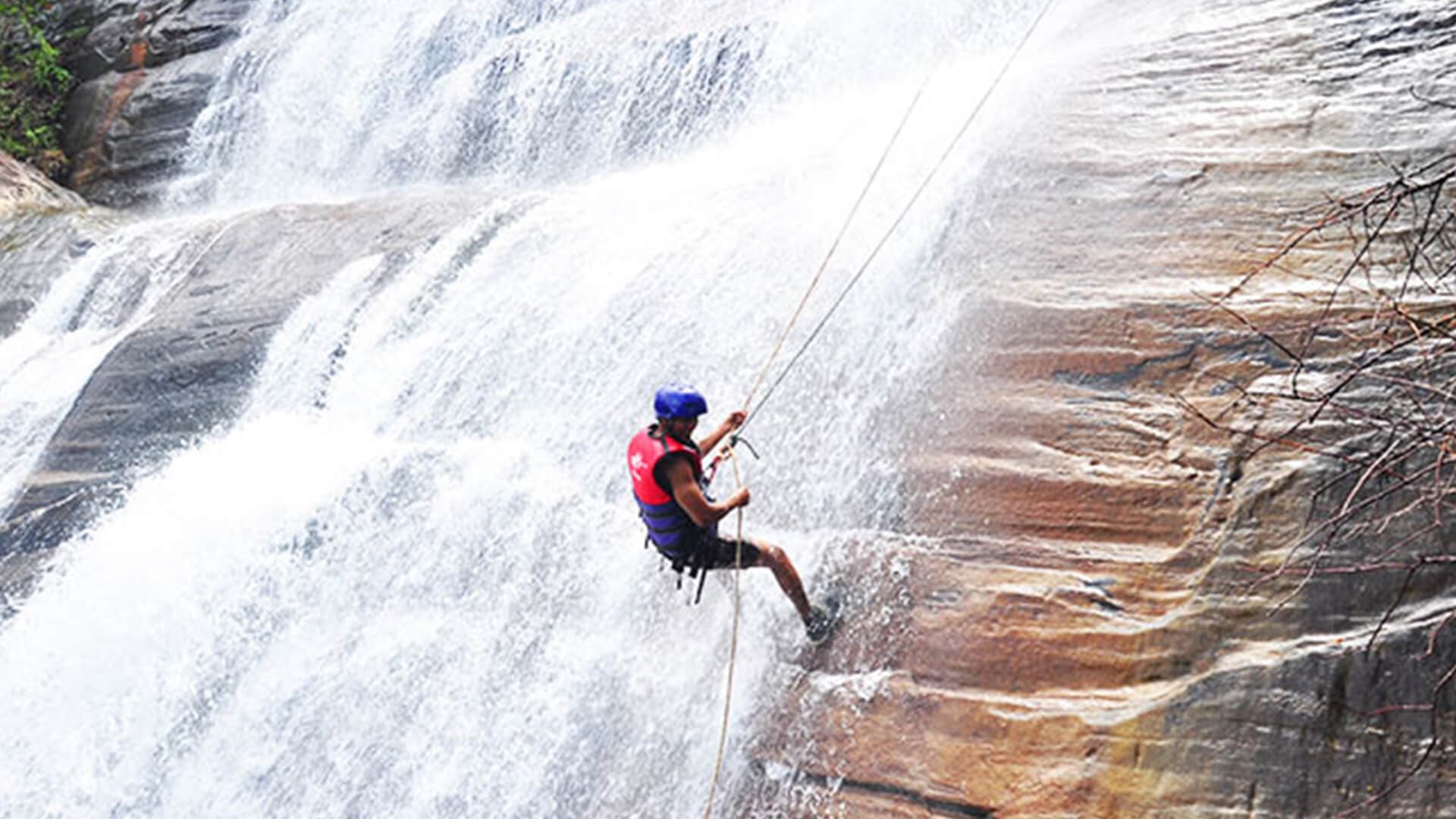 Das Wasser fließt grob im Kithulgala-Wasserfall und sorgt in Sri Lanka für Nervenkitzel beim Abseilen
