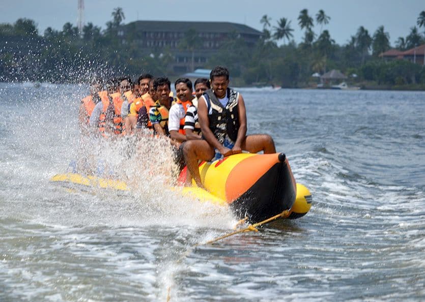 Группа туристов получает опыт катания на лодке-банане в Бентоте, Шри-Ланка.