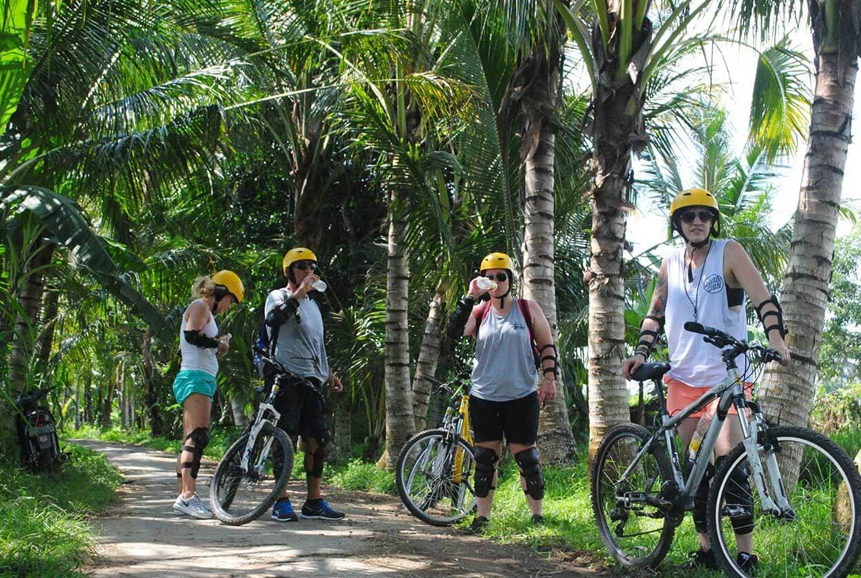 在棕榈树的景色中休息一下骑自行车的人