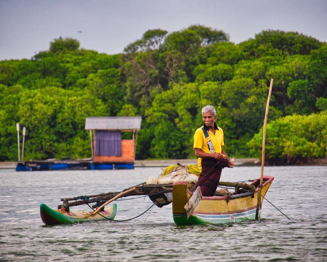 Ein dramatischer Blick auf einen Pontonfahrer im wunderschönen See in Udawalawe nach Mirissa Route in Sri Lanka