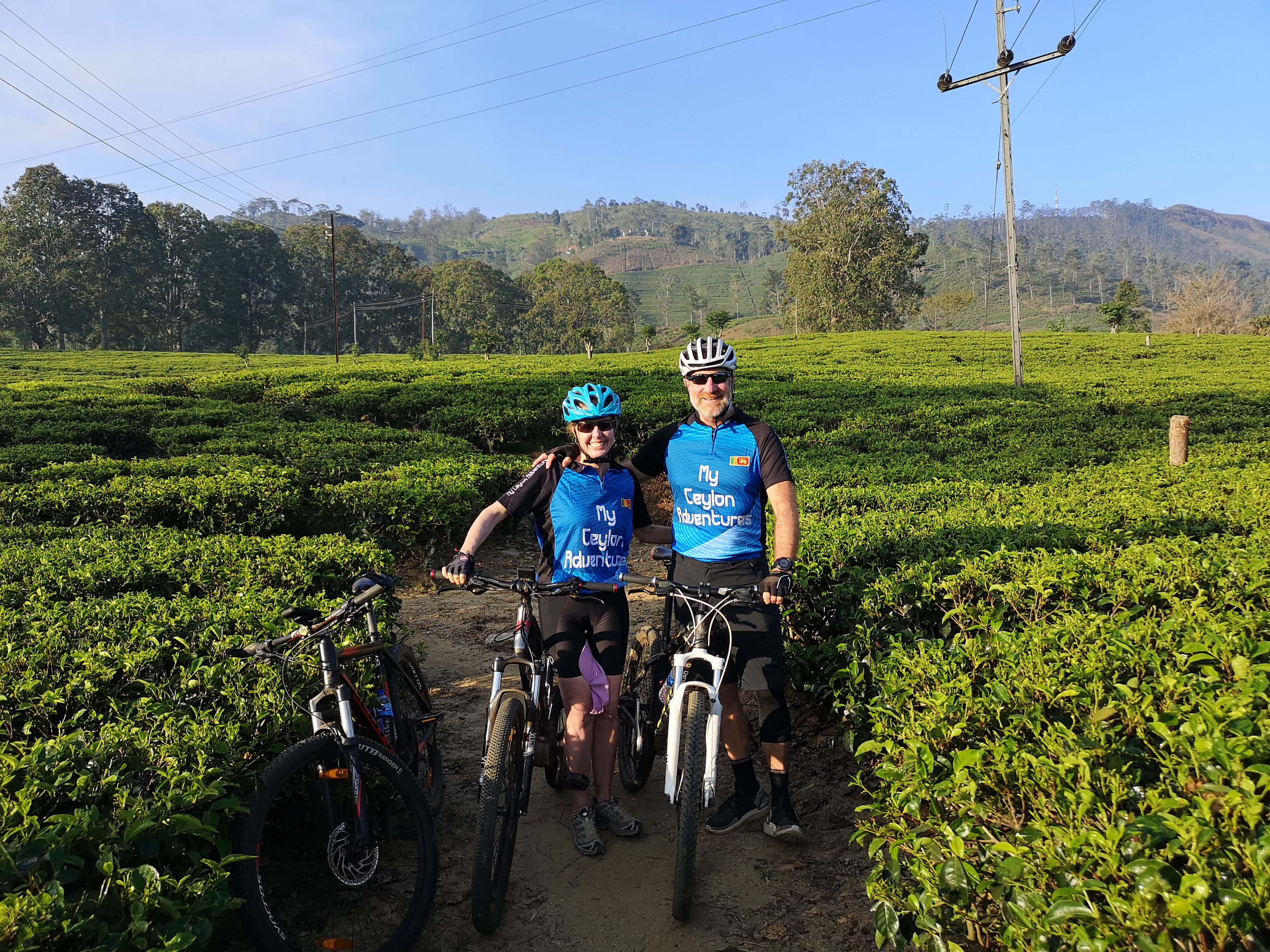 Dos ciclistas toman una foto en una hermosa zona de plantaciones de té en Kandy