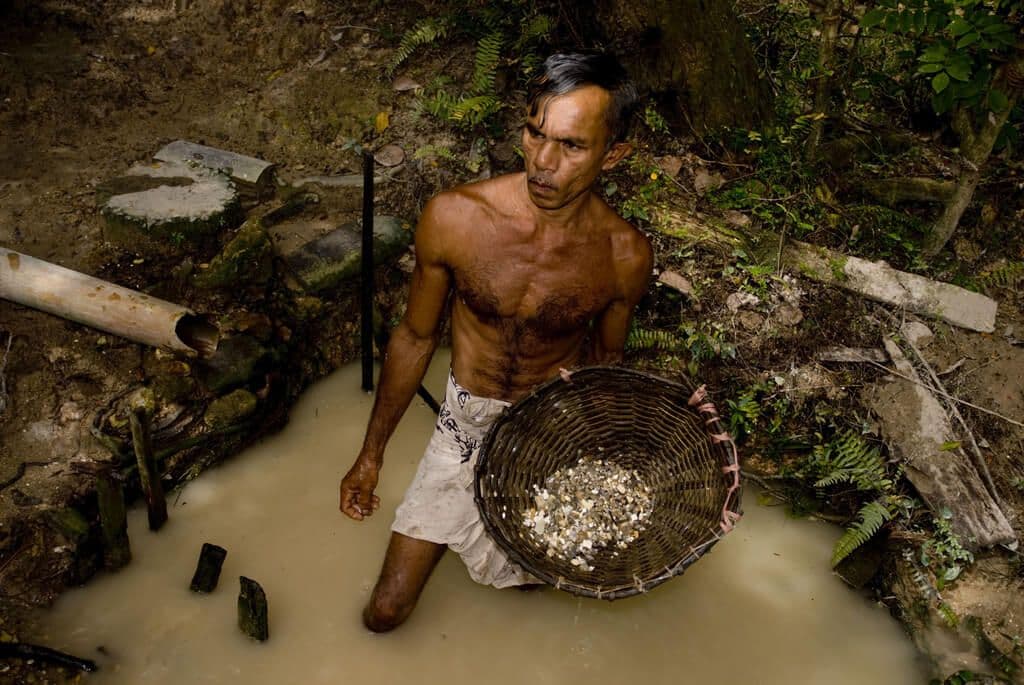 El trabajador está lavando las piedras extraídas de la mina de piedra lunar en Sri Lanka