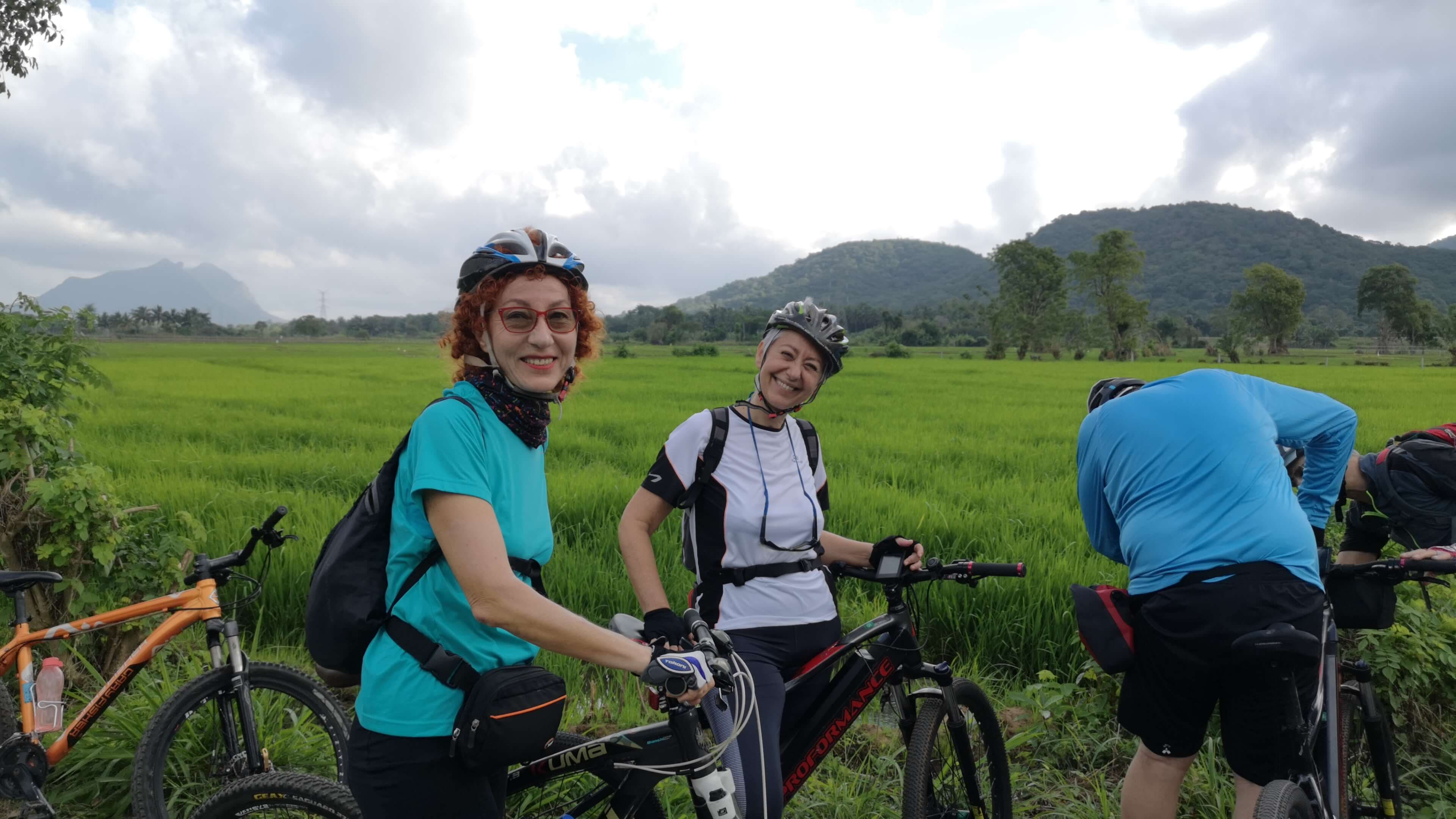Los turistas en bicicleta cerca de un hermoso campo de arroz en Polonnaruwa Sri Lanka