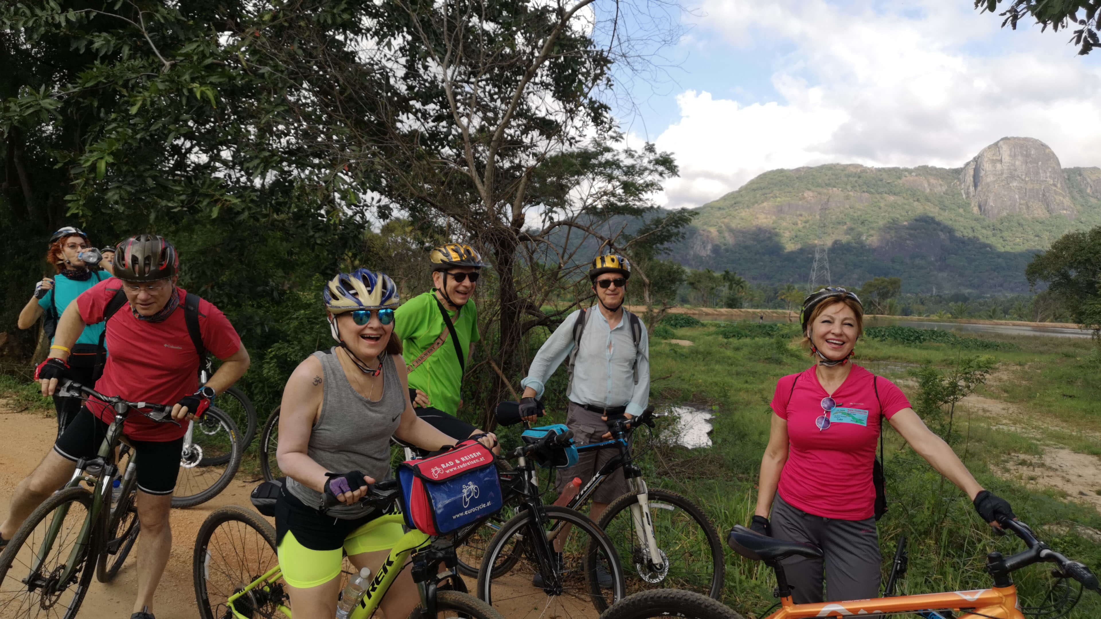 Группа счастливых велосипедистов отдыхает во время велосипедного тура по Удавалаве, изучающего красоту природы.