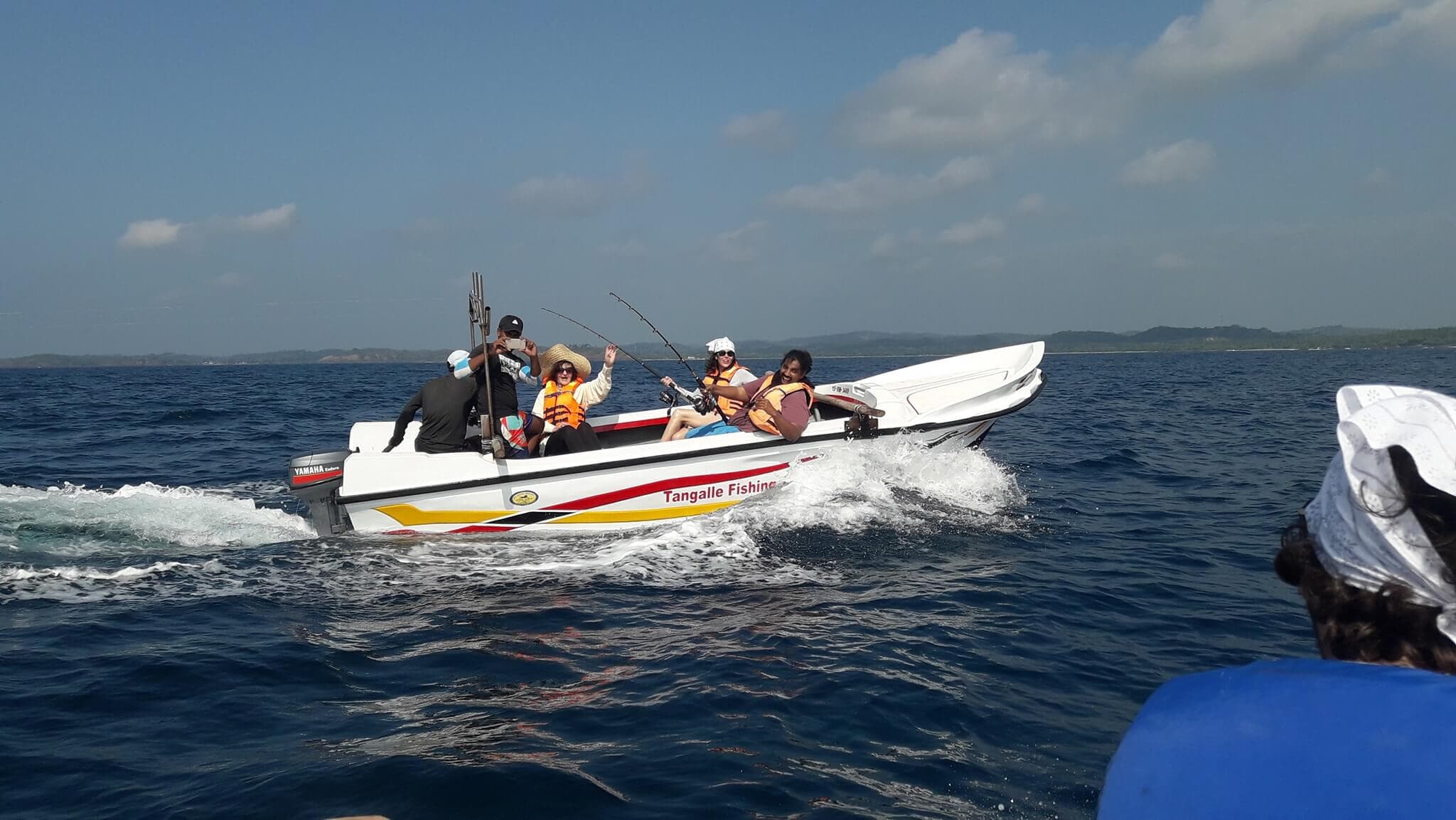 Los turistas viajan con un barco de pesca para pescar en el mar de Tangalle