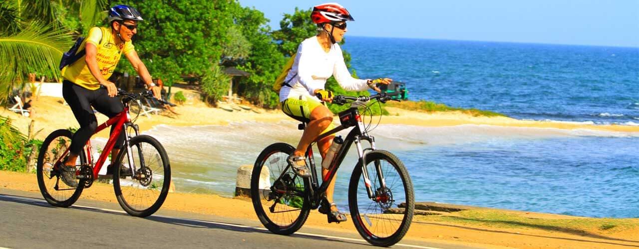 Una fotografía de dos ciclistas en bicicleta con la sensación de la hermosa playa de Unawatuna