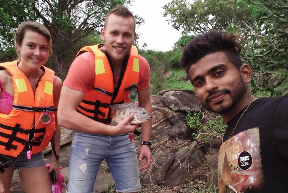 Los turistas capturan un pez Thilapiya en Polonnaruwa Sri Lanka