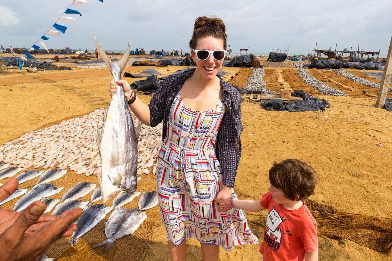 امرأة وطفلها يستكشفان إنتاج الأسماك الجافة في نيجومبو في سريلانكا