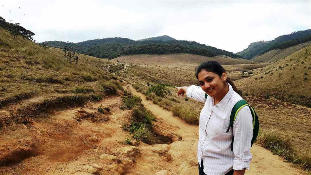 Una niña Trekking en el paisajismo de pastizales en Horton Plain Sri Lanka