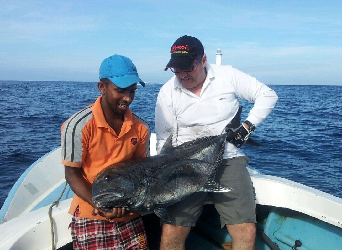 Турист ловит большую рыбу с хорошим руководством в Яла, Шри-Ланка.