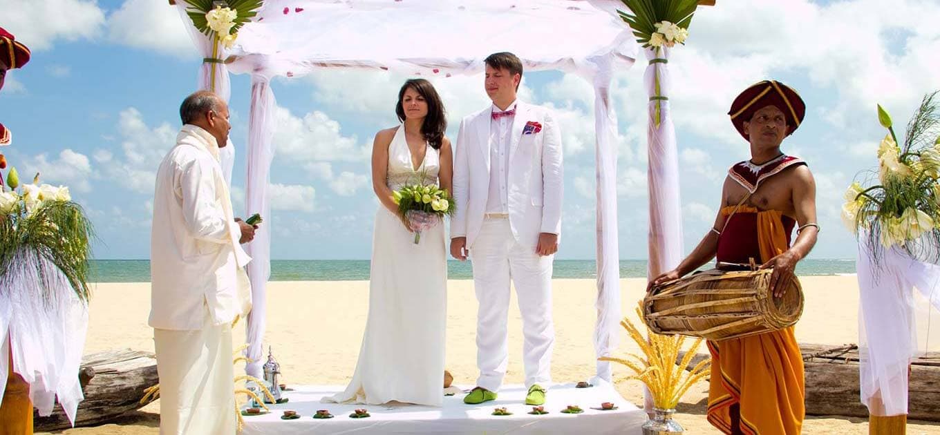 حفل زفاف يتم تنظيمه وفقًا للتقاليد السريلانكية لزوجين أجنبيين يقام على الشاطئ.