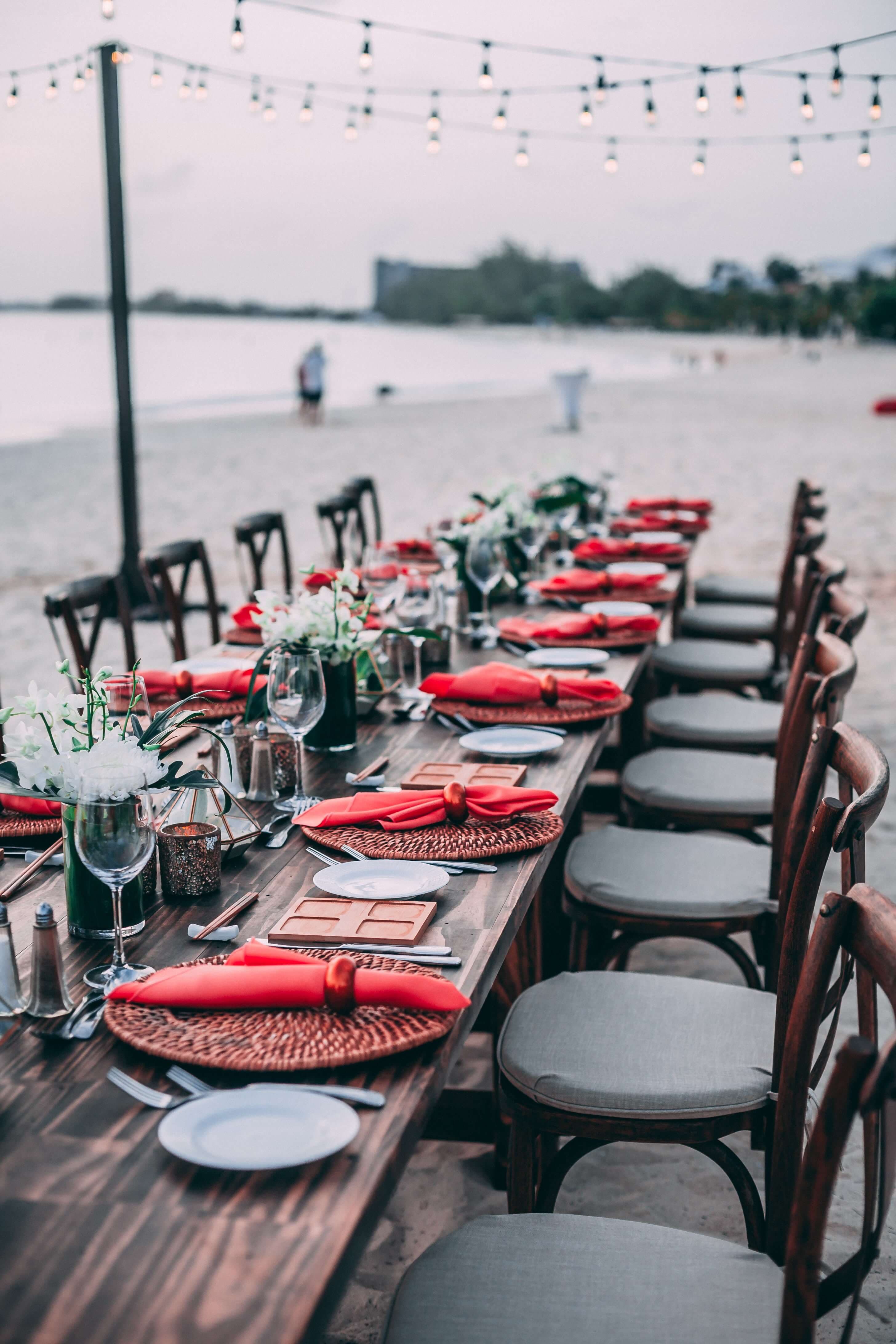 طاولة شاطئية معدة لحدث زفاف يقام على الشاطئ.