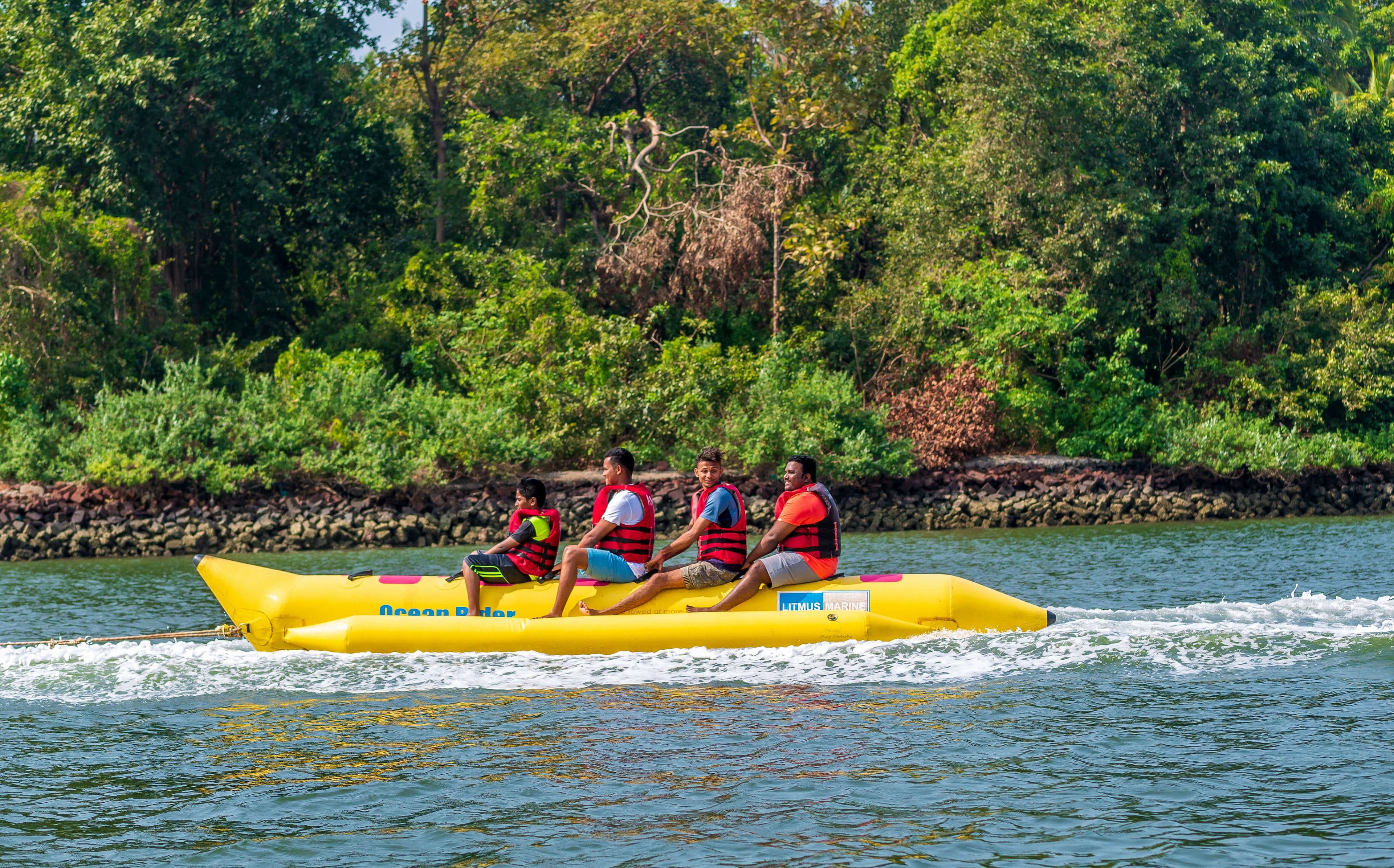 Vier Personen im Bananenboot, die die Natur in Bentota, Sri Lanka, genießen