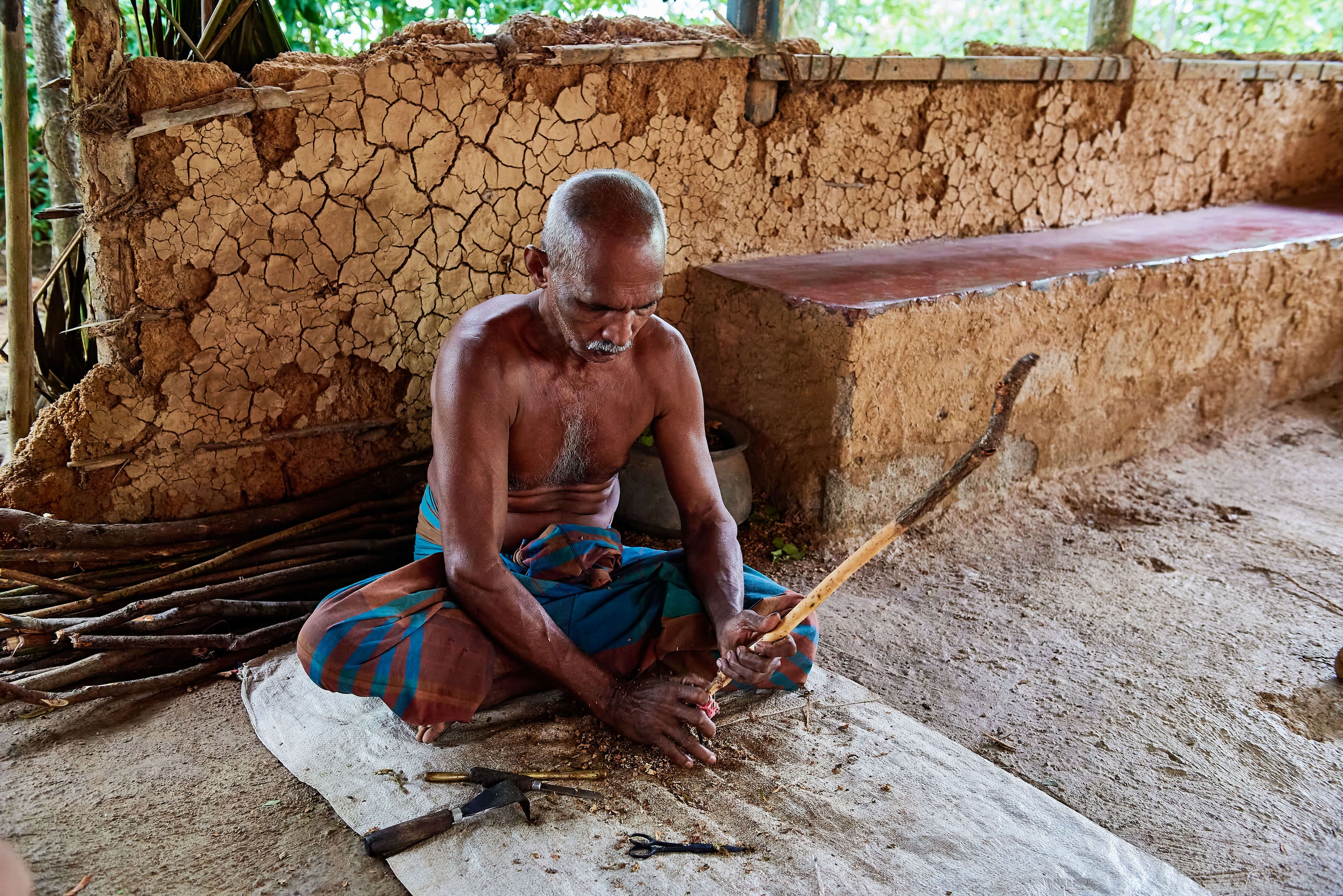 A photograph of a man making cinnamon in Galle