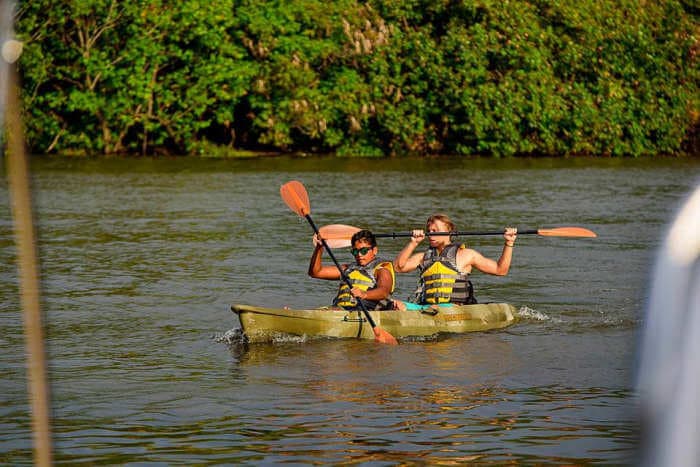 Two of tourists paddle on the Bentota river in the sun shine