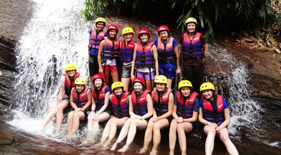 A group photo of tourists do canyoning in waterfall in Kithulgala