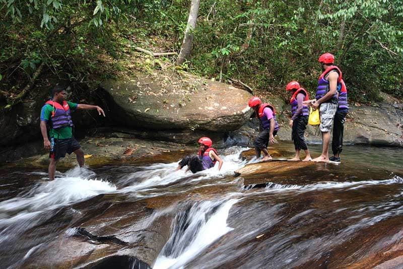 A family do canyoning in beautiful water stream in Kithulgala