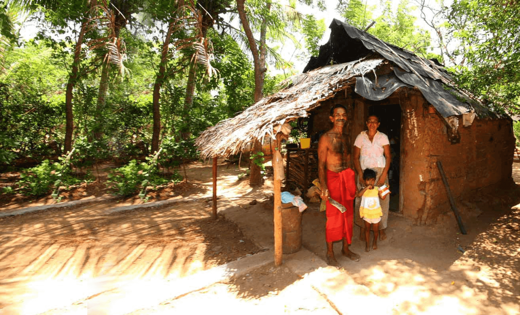 A photo of a small family in rural 'mud' house in Yala countryside Sri Lanka