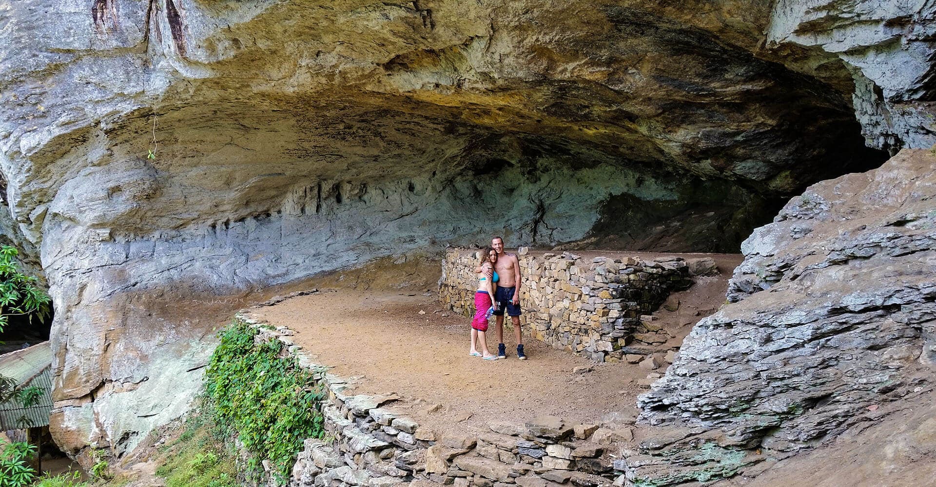 Front view of Beli Lena Cave and a tourist couple in Kithulgala Sri Lanka