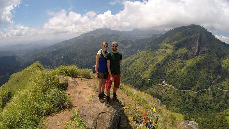 A photograph of a tourist couple in the top of Ella mountain place 