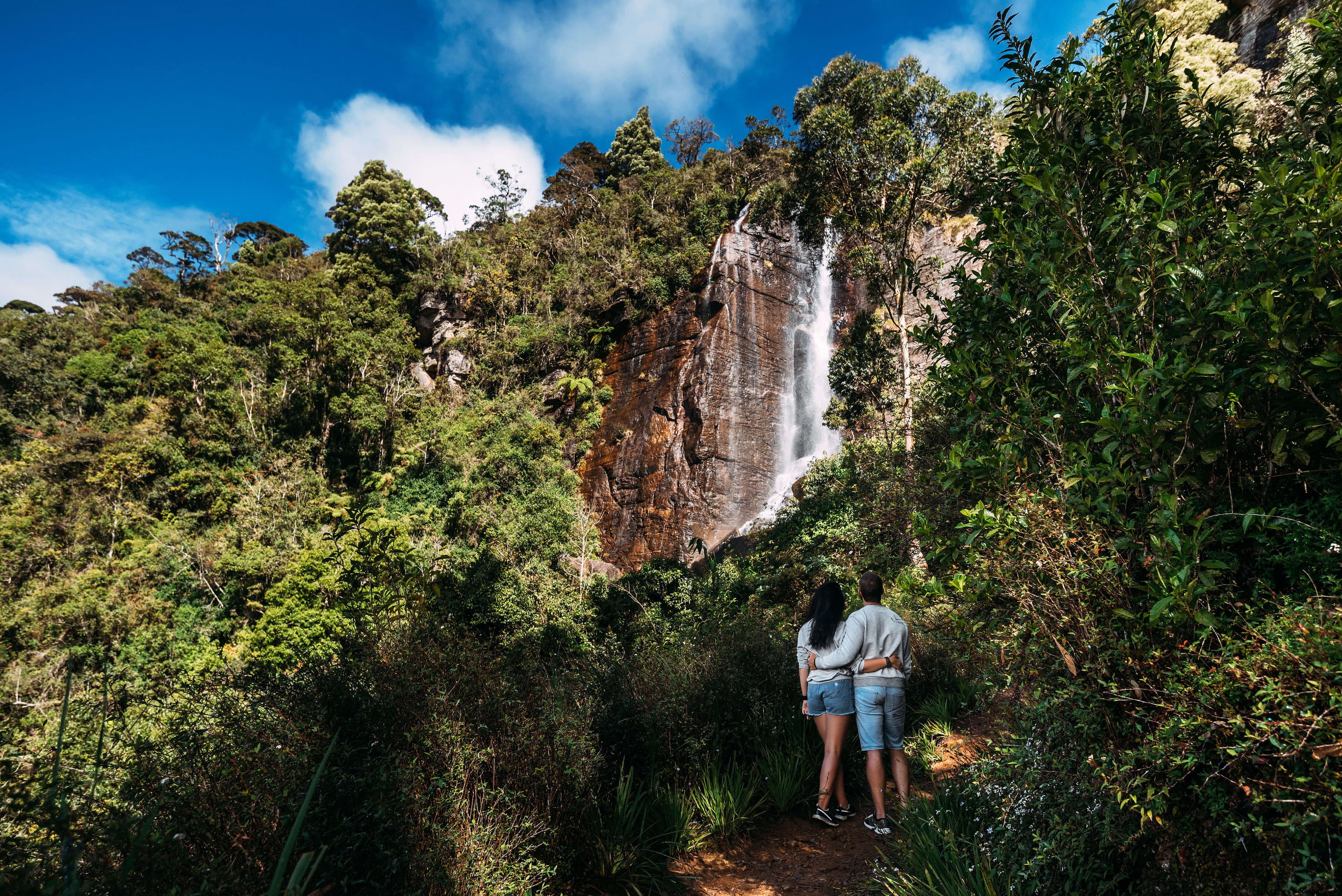 A couple explore the beauty of nature and the waterfall 