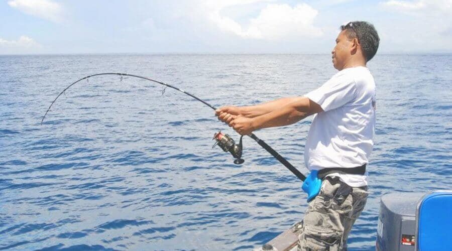 The man catching a fish from his rod in the fishing tour in Hikkaduwa Sri Lanka