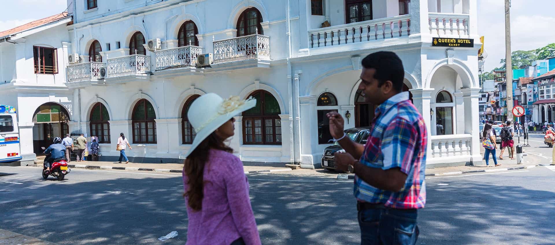 Give some explanation to the tourist in front of the Queen's hotel Sri Lanka