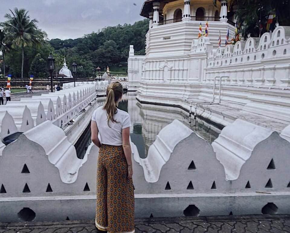 A tourist woman take a photo in front of 'Paththirippuwa' in Kandy Sri Lanka 