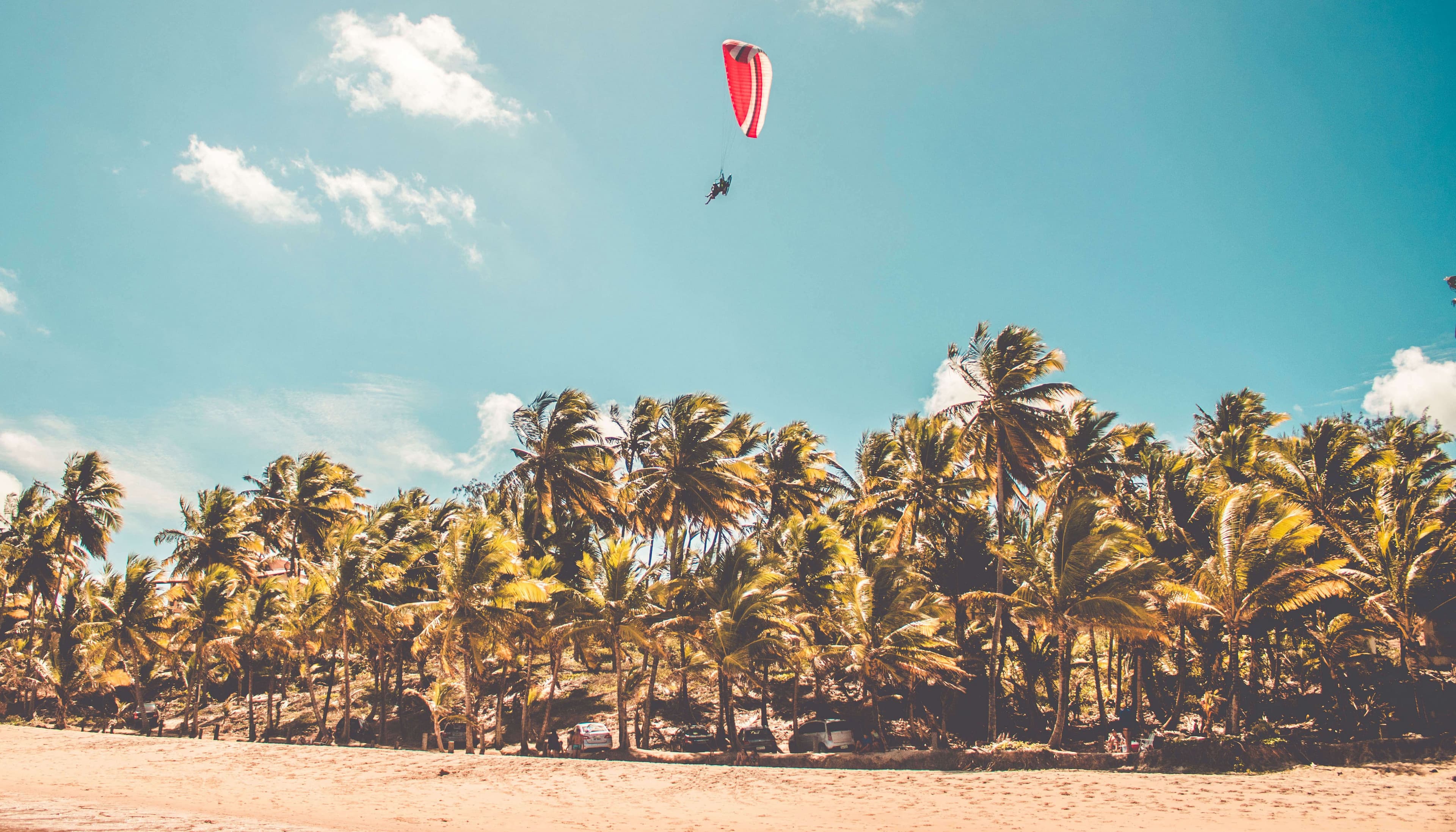 Paraglider flying over the beach in bright sunny day in Bentota Sri Lanka