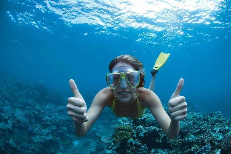 A woman snorkeling happily in underwater sea in Negombo Sri Lanka
