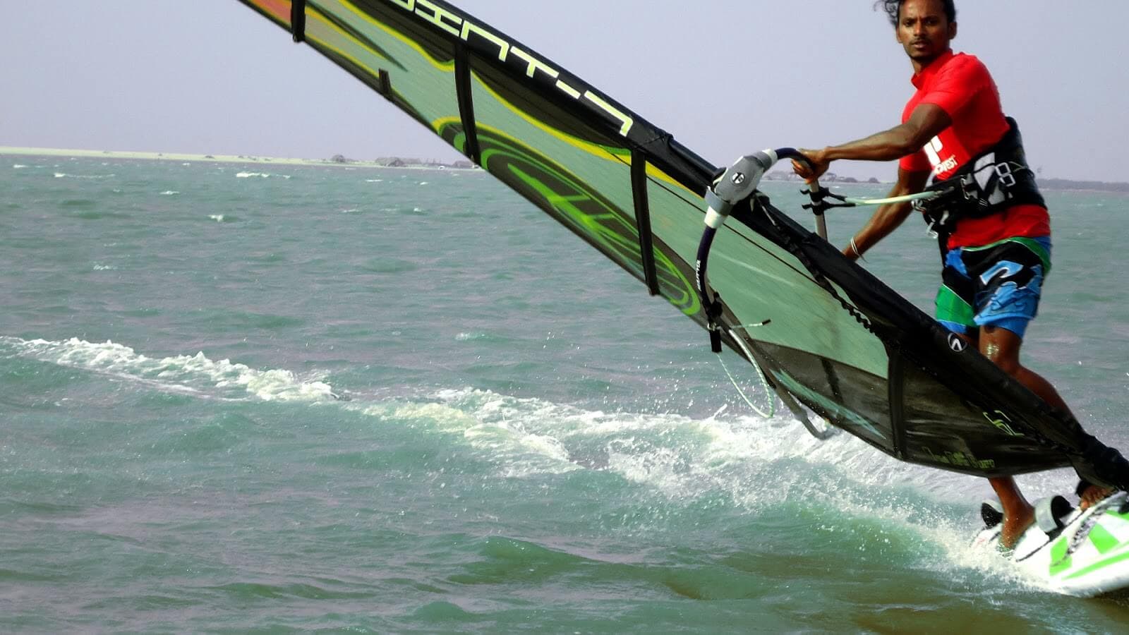 A photo of windsurfing man with fully equipped safety on Bentota golden coast Sri Lanka