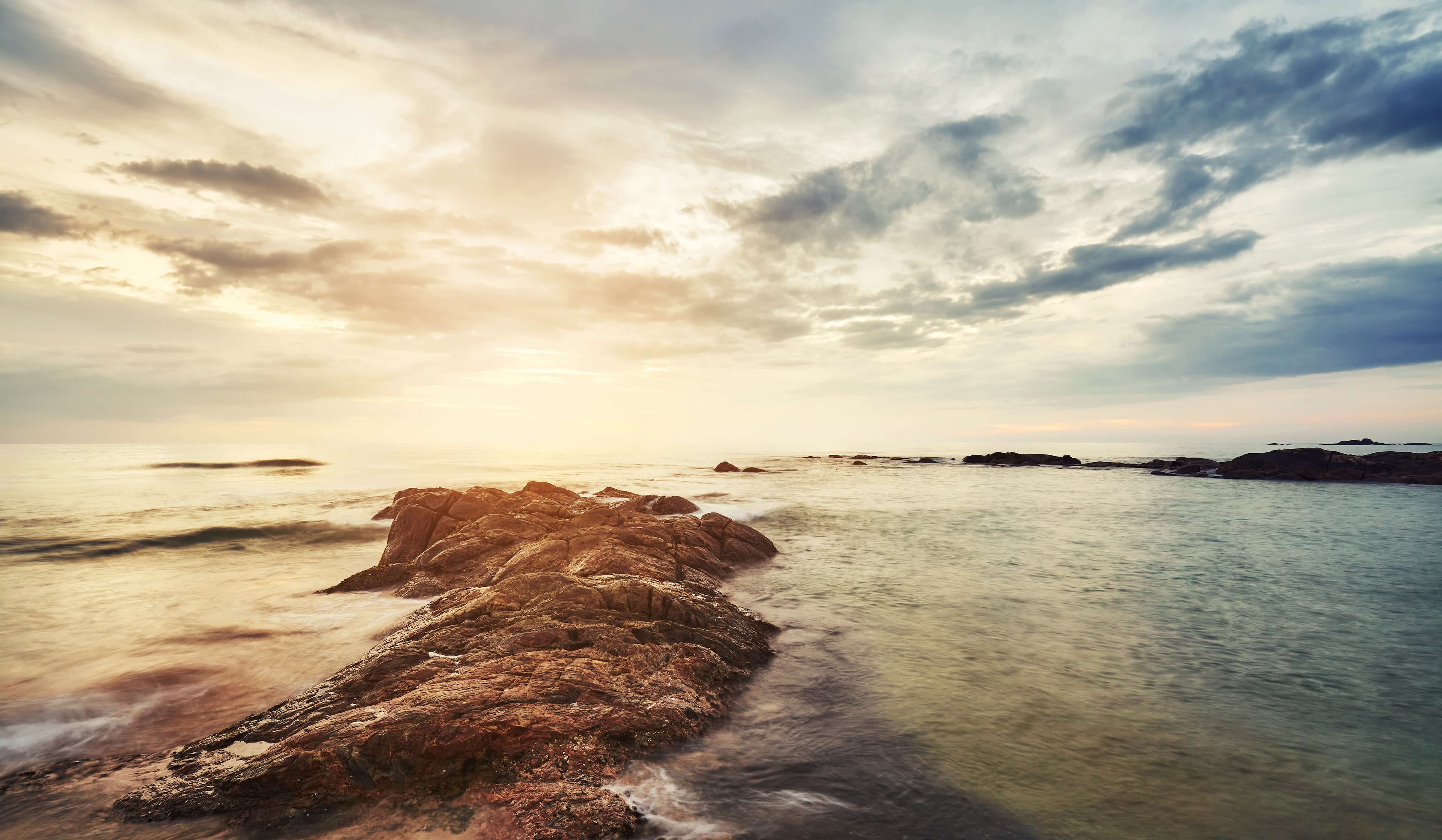 在斯里兰卡本托塔的一个岩石海滩上的风景秀丽的日落。