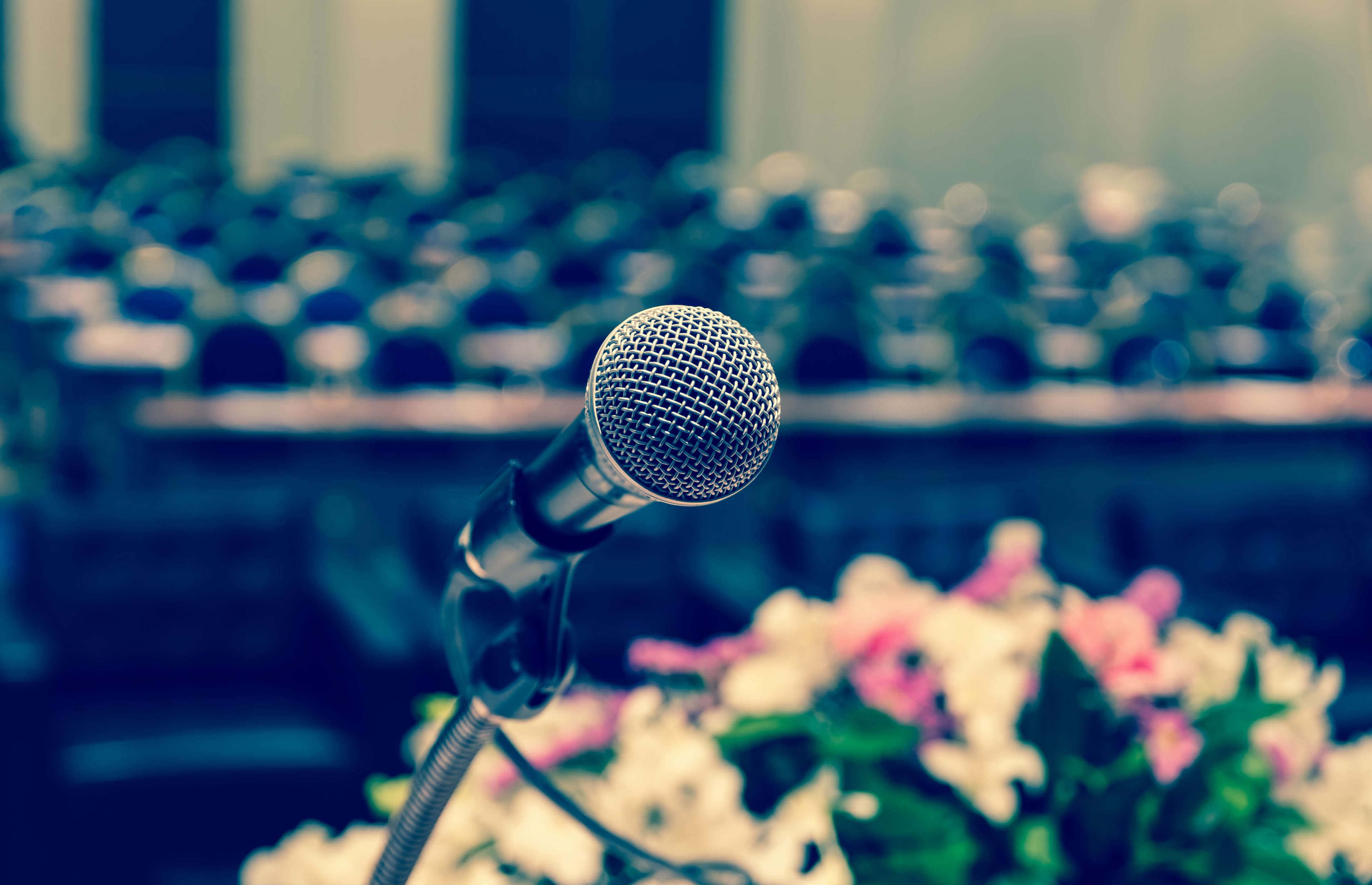 Microphone over the conference hall or seminar room background.