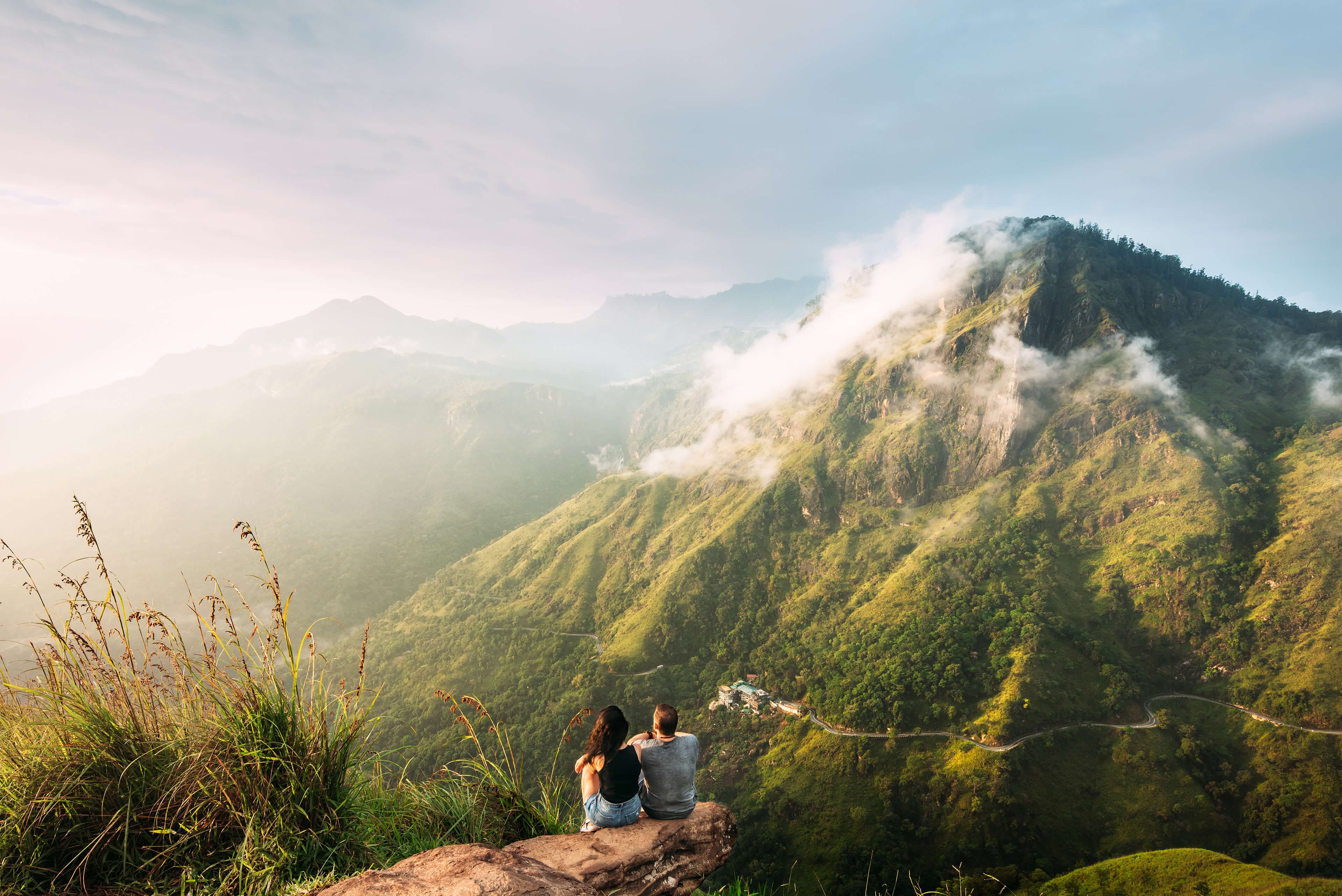 Das Paar begrüßt den Sonnenaufgang in den Bergen von Ella, Sri Lanka.
