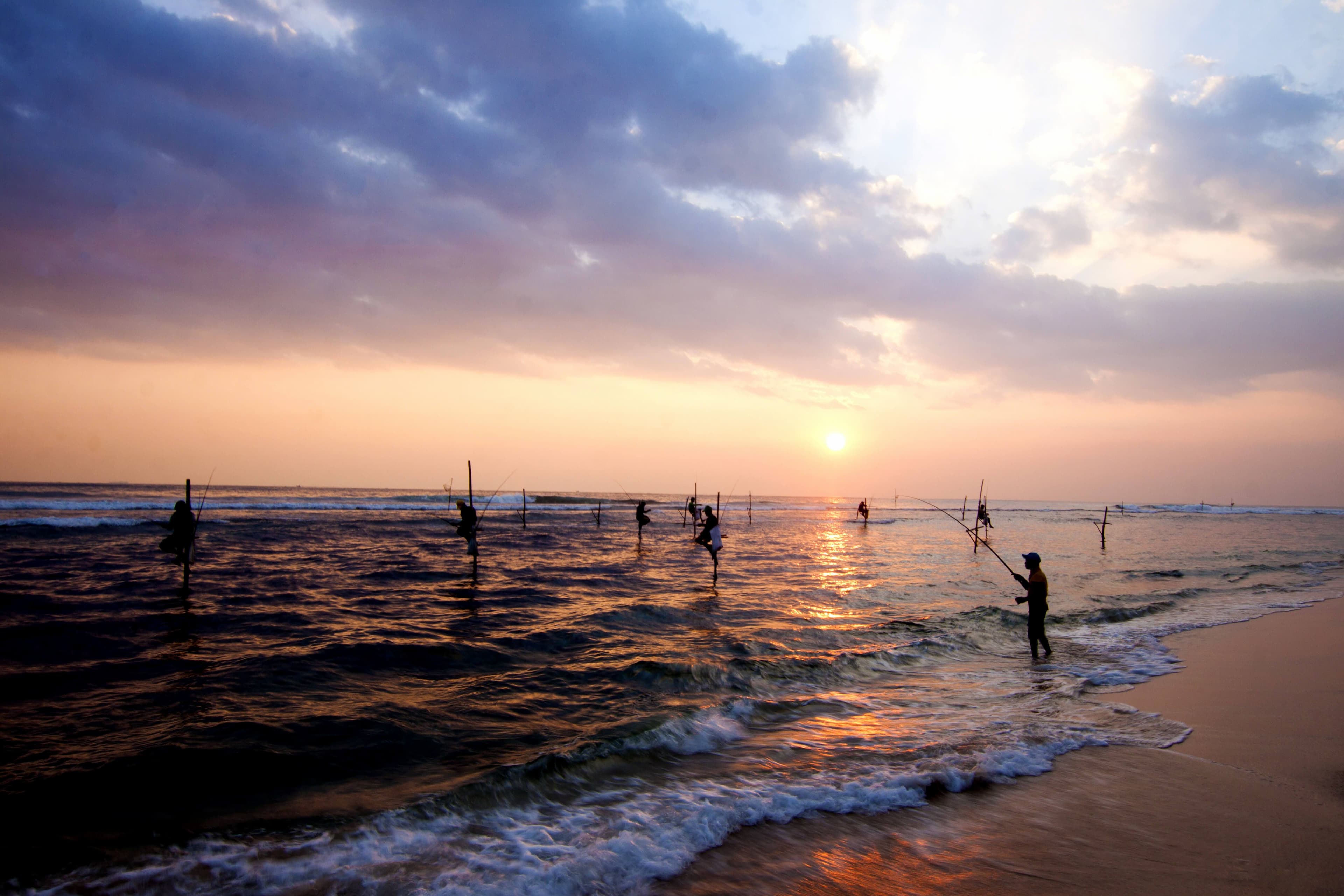 Silhouettes of the traditional stilt fishermen at the sunset near Galle, Sri Lanka.