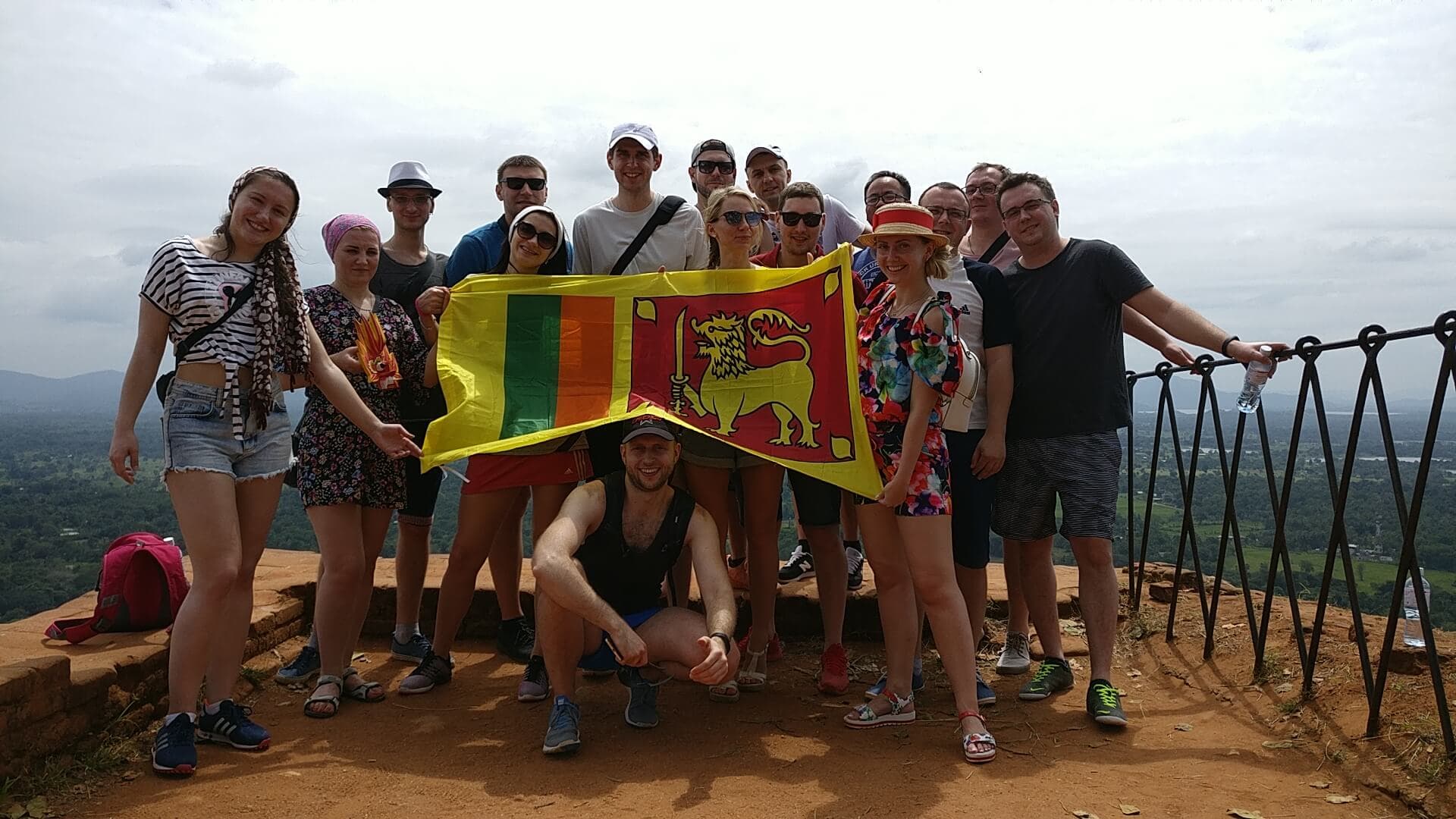 A group of people holding the Sri Lankan flag while participating on incentive activities.